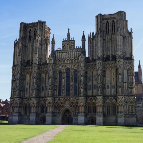Wells Cathedral in a green field with a blue sky