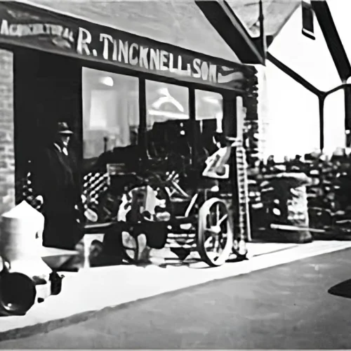 A black and white image of the Tincknell store, with old-fashioned bikes and products at the front